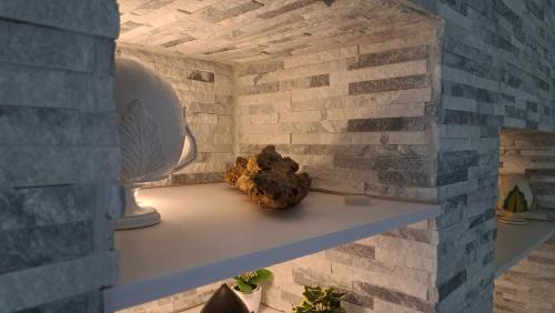 a room with a brick wall and a shelf with a rock at Casa Margherita in Noci