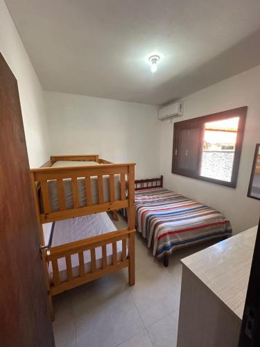a room with two bunk beds and a window at Barra de Ibiraquera in Barra de Ibiraquera