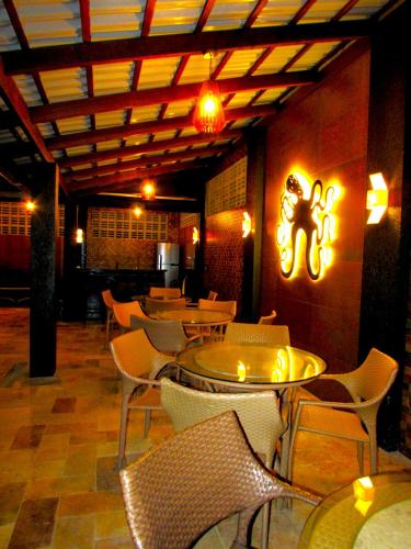 a dining room with tables and chairs and lights at Mar e Lar in Maragogi