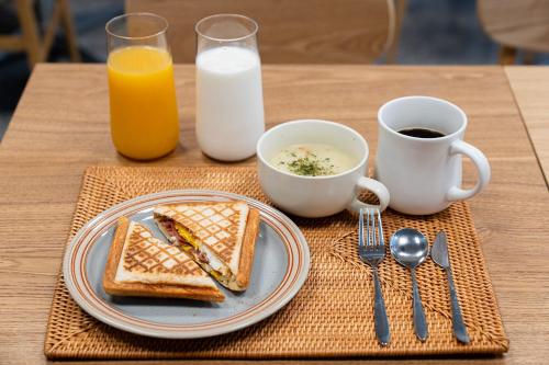 a table with a plate of toast and coffee and milk at Hound hotel gunsan in Gunsan