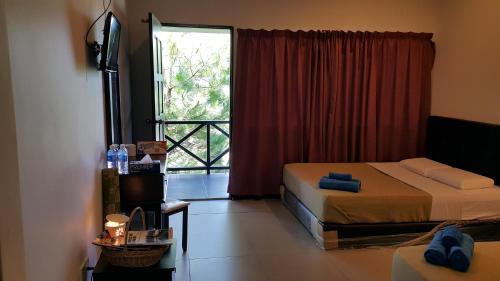 a bedroom with two beds and a sliding glass door at Crystal Hill R in Kundasang