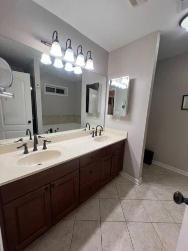 a bathroom with two sinks and a large mirror at Spacious Gorgeous 3bd home with large deck Close to EVERYTHING in Atlanta