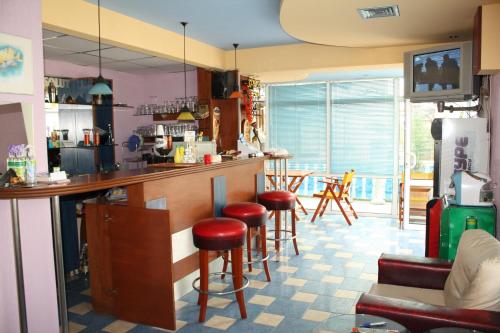 a kitchen with a bar with red stools at Villa Amadeus in Nesebar