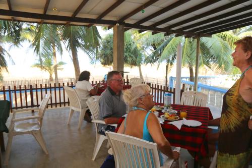 a group of people sitting at a table at a restaurant at Topaz Beach Hotel in Negombo
