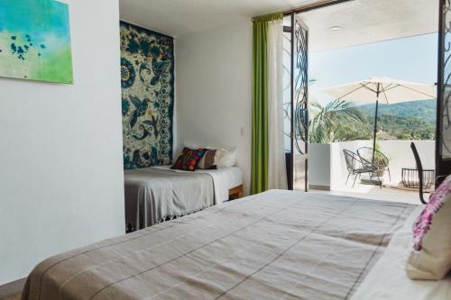 a bedroom with a bed and a balcony with a view at Casa Fenix in Sayulita