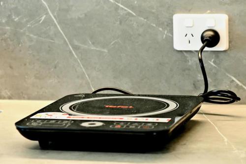 a black phone plugged into an electrical outlet at RiverView GetAway in Maroochy River