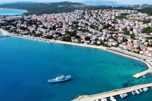 a boat in the water near a large city at Apartments by the sea Novalja, Pag - 11512 in Novalja
