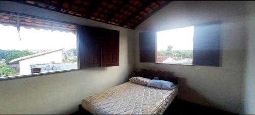 a bedroom with two windows and a bed in it at Casa de praia Maçarico in Salinópolis