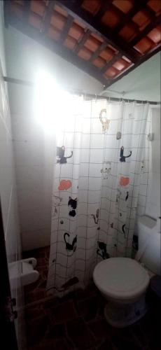 a bathroom with a toilet and a tiled wall at Casa de praia Maçarico in Salinópolis