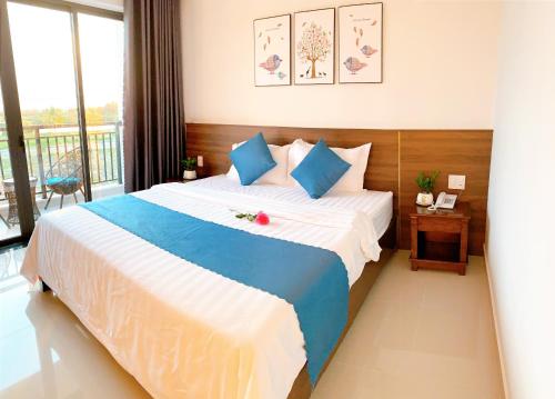 a bedroom with a large bed and a balcony at EasyLife Villa Hoi An in Tân Thành (1)