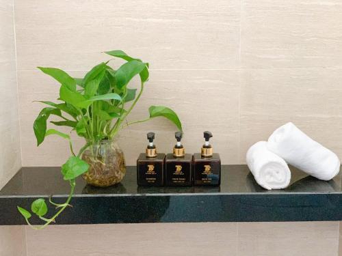a bathroom counter with three soap dispensers and a plant at EasyLife Villa Hoi An in Tân Thành (1)