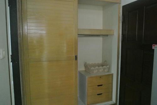 a closet with a wooden door and a dresser at Oriental Smile Hotel in Bangkok