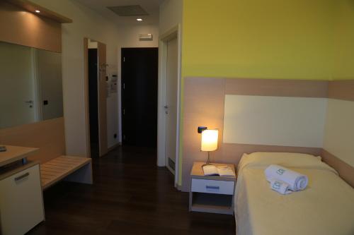 a bedroom with a bed and a lamp on a table at Groane Hotel Residence in Cesano Maderno