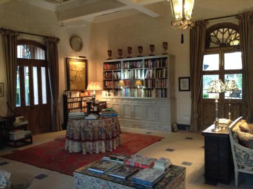 a living room with a large book shelf filled with books at Bujera Fort in Udaipur