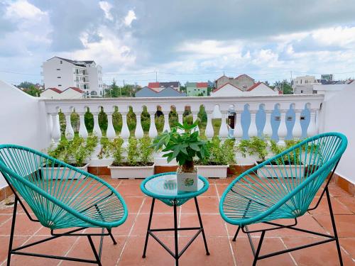 two chairs and a table on a balcony with a fence at EasyLife Villa Hoi An in Tân Thành (1)