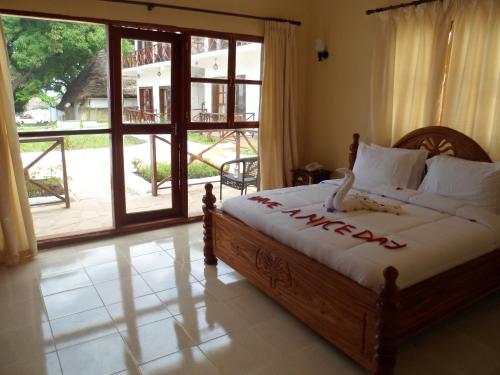 een slaapkamer met een bed en een grote glazen schuifdeur bij Zanzibar Ocean View Hotel in Zanzibar City