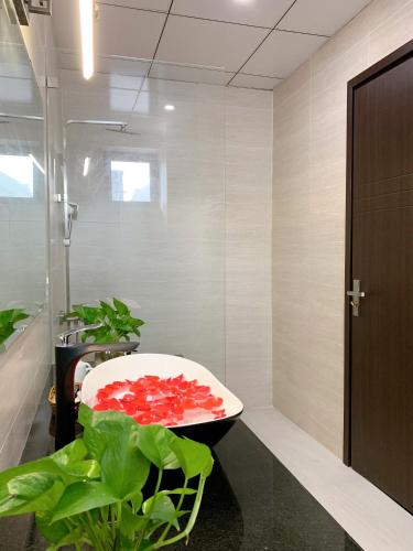 a bathroom with a bath tub filled with red flowers at EasyLife Villa Hoi An in Tân Thành (1)