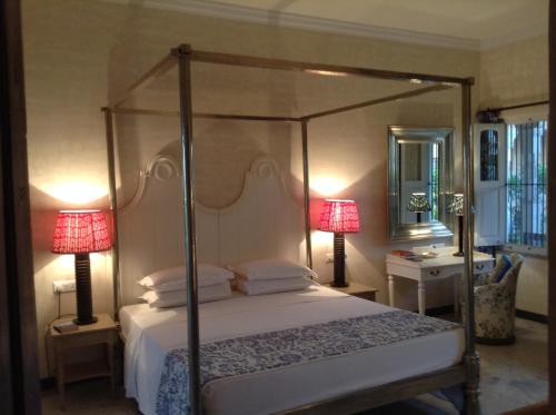 a bedroom with a canopy bed and two lamps at Bujera Fort in Udaipur
