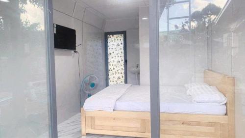 a bedroom with a bed and a glass wall at Huy Hoàng Homestay Kiên Giang in Lai Sơn