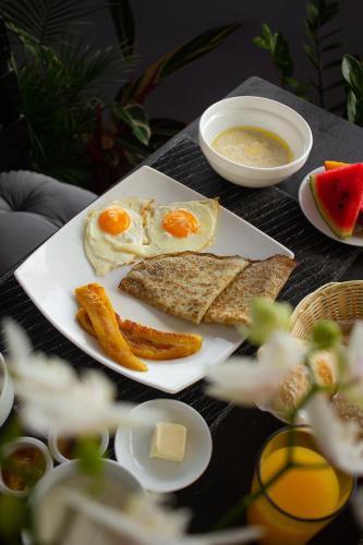 a table with a plate of food with eggs and bread at Nosara Hideaway 3 - BREAKFAST INCLUDED & Mountain View Cabins in Nosara