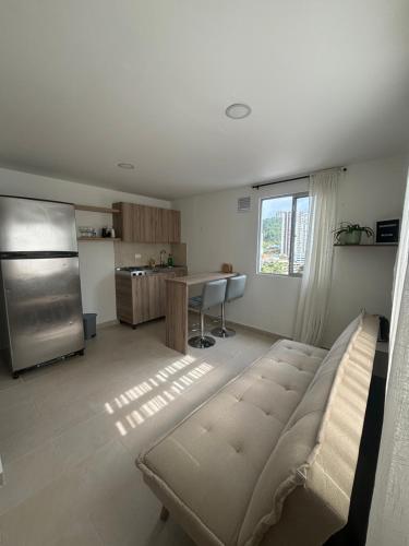 a living room with a stainless steel refrigerator and a kitchen at Apartamento acogedor cerca al Cable in Manizales