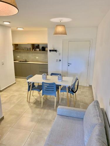 a dining room with a white table and blue chairs at Allende Apart St in Villa Allende