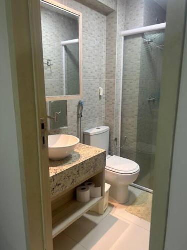a bathroom with a sink and a toilet and a shower at Tabatinga Flat - Pé na Areia! Beira Mar! in Conde