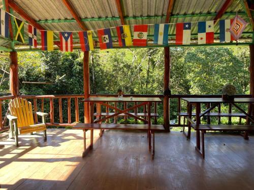 a porch with a table and chairs and flags at Centro Ecológico Montaña Verde in Rivas