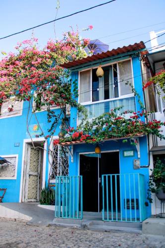 a blue building with flowers on the front at La Estacion Hostel - Pipa in Pipa