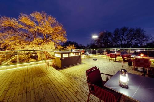a deck with tables and chairs at night at Guipu Beihai Courtyard Hotel Beijing in Beijing
