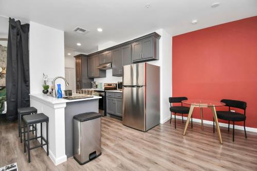 a kitchen with a stainless steel refrigerator and a table at Serenity Studios - Near Med Center & Museum District in Houston