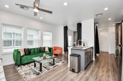 a living room with a green couch and a table at Serenity Studios - Near Med Center & Museum District in Houston