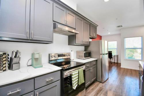 a kitchen with stainless steel appliances and wooden floors at Serenity Studios - Near Med Center & Museum District in Houston
