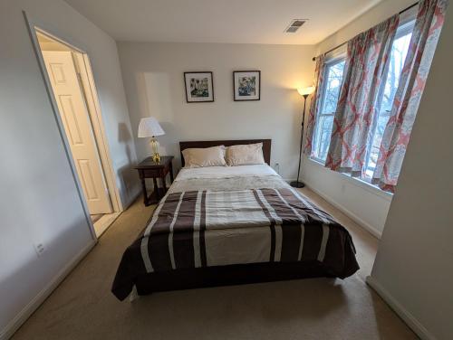 a bedroom with a bed and a large window at 3 Bedroom Townhouse 8 Miles to Washington DC in Falls Church