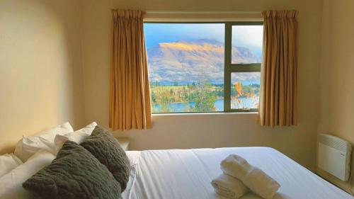 Un dormitorio con una cama con vistas a la montaña. en Walk to Town center with Views, en Queenstown