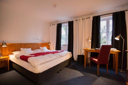 a bedroom with a bed and a desk and a chair at Hotel Bürkle in Fellbach