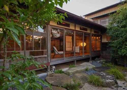 a house with glass doors and a yard at NIPPONIA Sawara Merchant Town Hotel in Katori