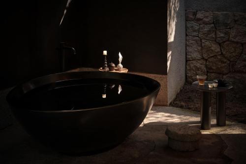 a dark bathroom with a black tub and a table at Yakamoz Qianchuan Hotel in Lin'an