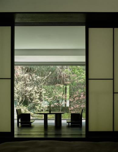 a room with a large window with a table and chairs at Yakamoz Qianchuan Hotel in Lin'an