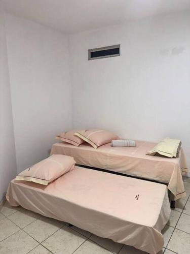 two beds sitting next to each other in a room at Excelente apartamento no centro in Macaé