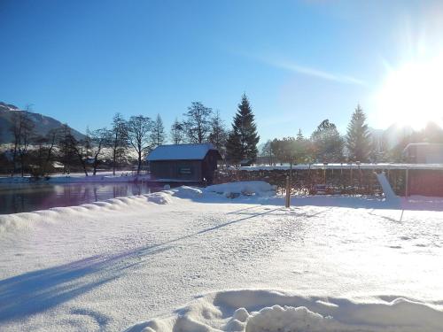 a snow covered road with a building in the background at Haus Seehof in Sankt Gilgen