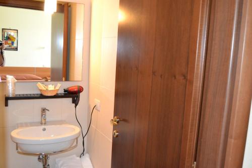 a bathroom with a sink and a toilet and a mirror at Albergo Umbria in Otricoli