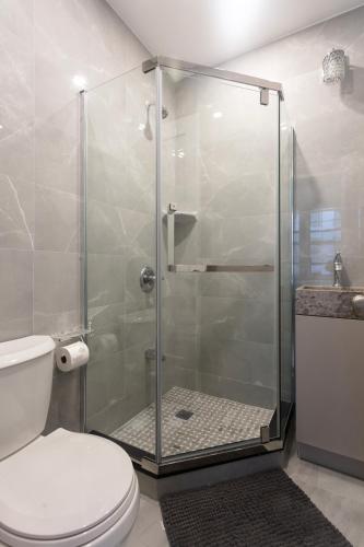 a bathroom with a glass shower with a toilet at Little manhattan near Time Square in New York