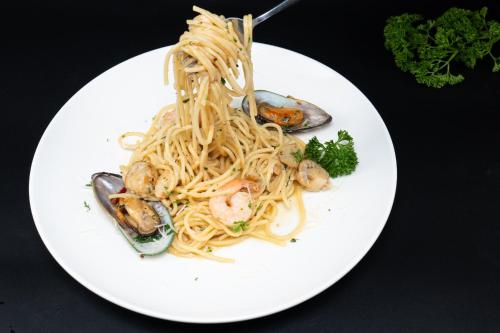 a plate of pasta with shrimp and other foods at Angkor Mansion & Residence in Siem Reap