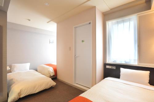 A bed or beds in a room at Vessel Inn Hiroshima Ekimae