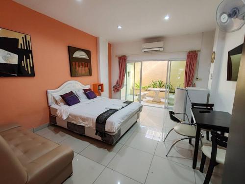a bedroom with a bed and a desk in it at Jomtien Hostel in Jomtien Beach