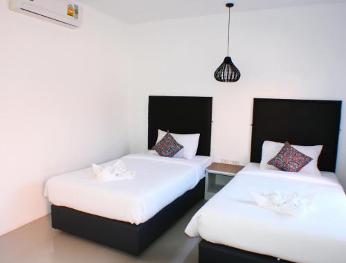 ランタ島にあるNon Du Lay Guesthouseの白いシーツが備わるベッド2台が備わる客室です。