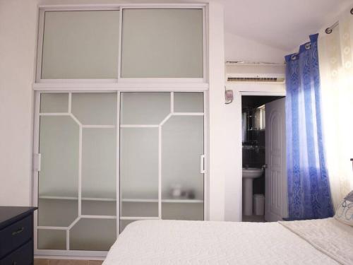 a bedroom with a large glass closet with a bed at Encantador Apartamento con agua caliente in Los Paredones