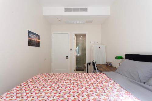 a bedroom with a bed with a orange and white blanket at Little manhattan near Time Square in New York