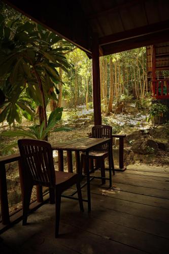 a wooden table and two chairs on a porch at Sambath Sakseth Bungalow in Koh Rong Island